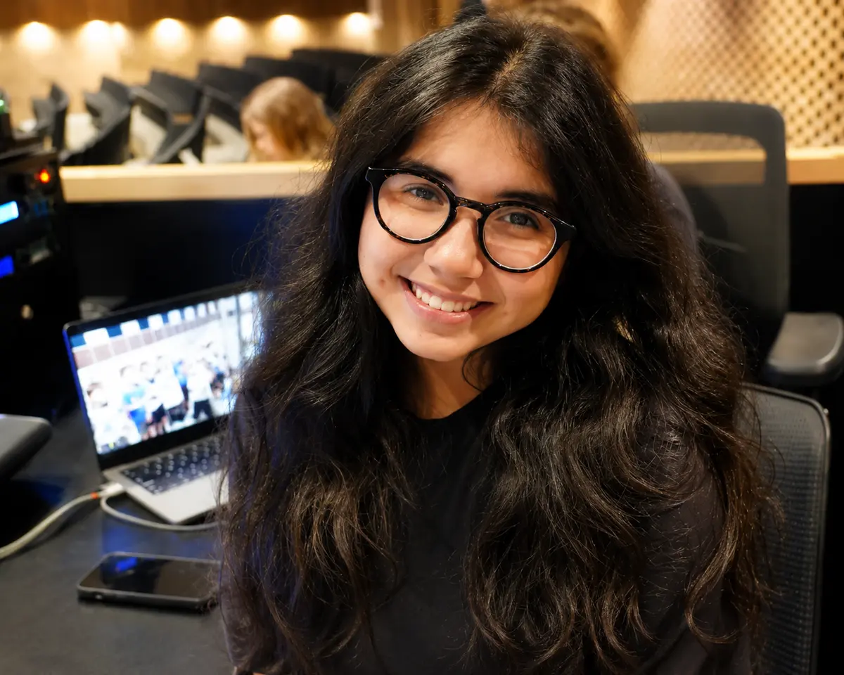 Isabella Gonzales smiling while seated near a sound board
